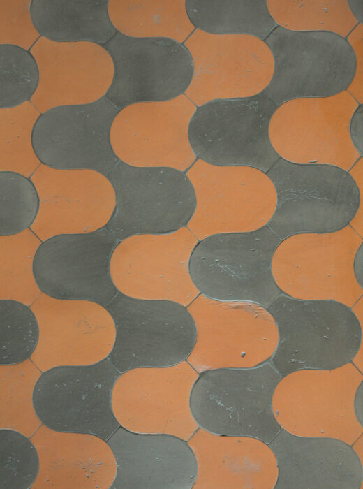 Pavimento in ceramica con piastrelle arancioni e grigie a forma di S.