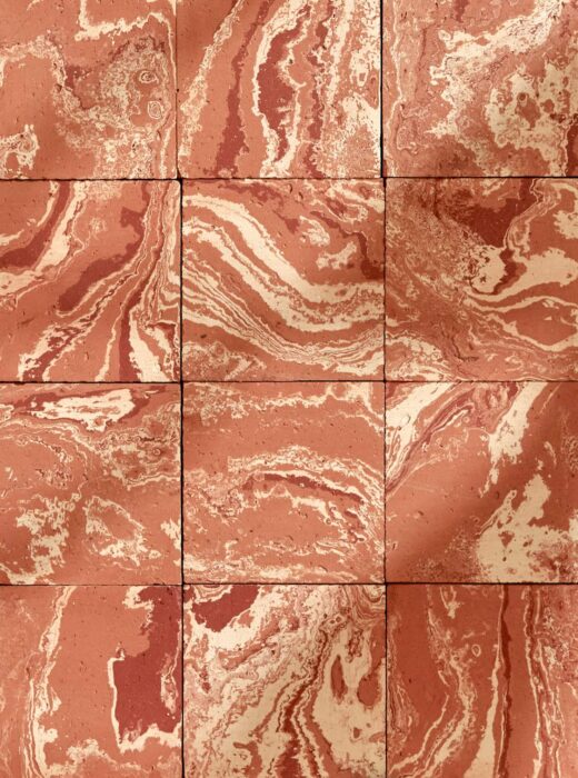 Rivestimento murale con piastrelle quadrate in terracotta con venature rosse e bianche.