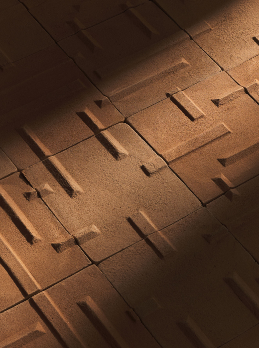 Pavimento rivestito con piastrelle in terracotta con motivo geometrico a linee orizzontali e verticali