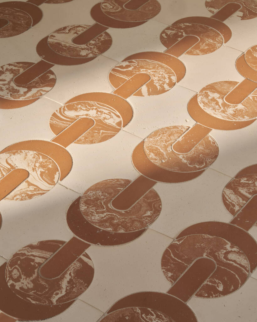 Pavimento con motivi circolari in terracotta su sfondo chiaro, decorato con finiture marmorizzate