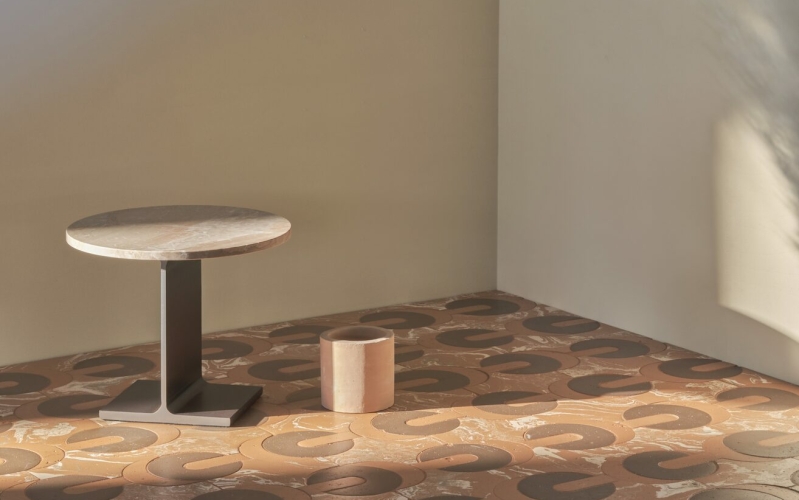 Pavimento in terracotta con motivi circolari, tavolino rotondo in marmo e cilindro decorativa